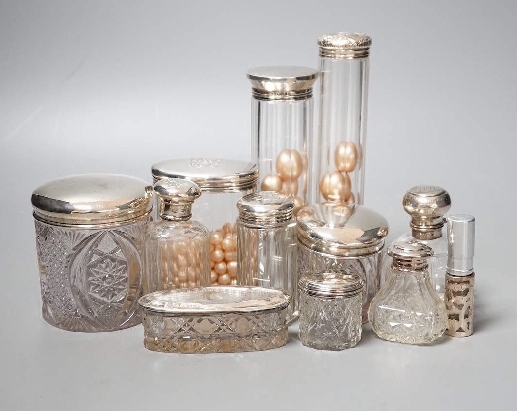 A group of assorted silver topped glass toilet bottles and a scent bottle.